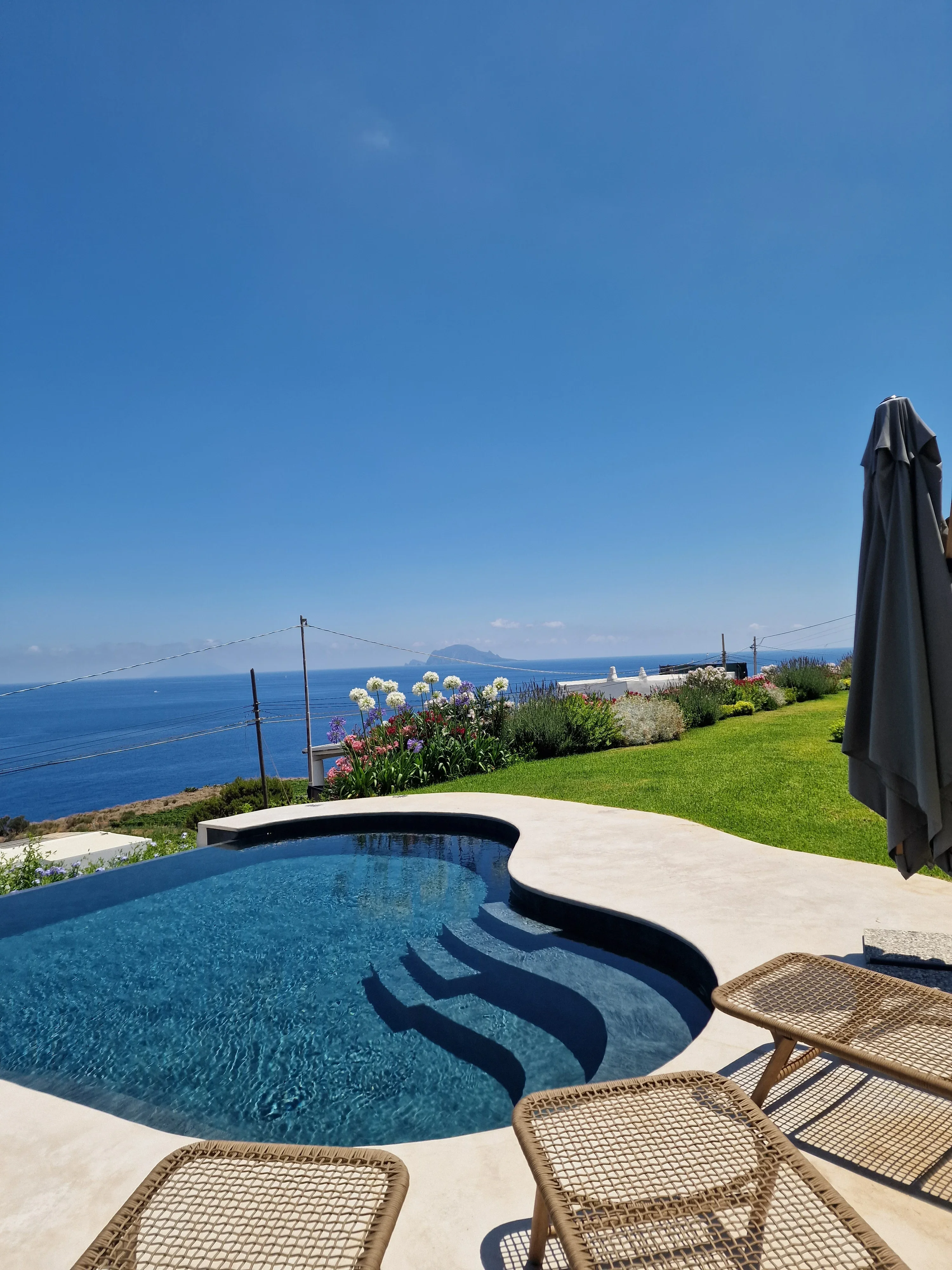 Piscina con vista sul mare e prato essenziale